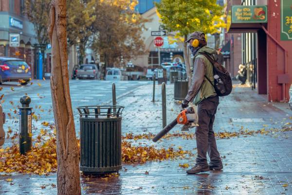 A man holding a leaf blower—electric leaf blower and gas leaf blower