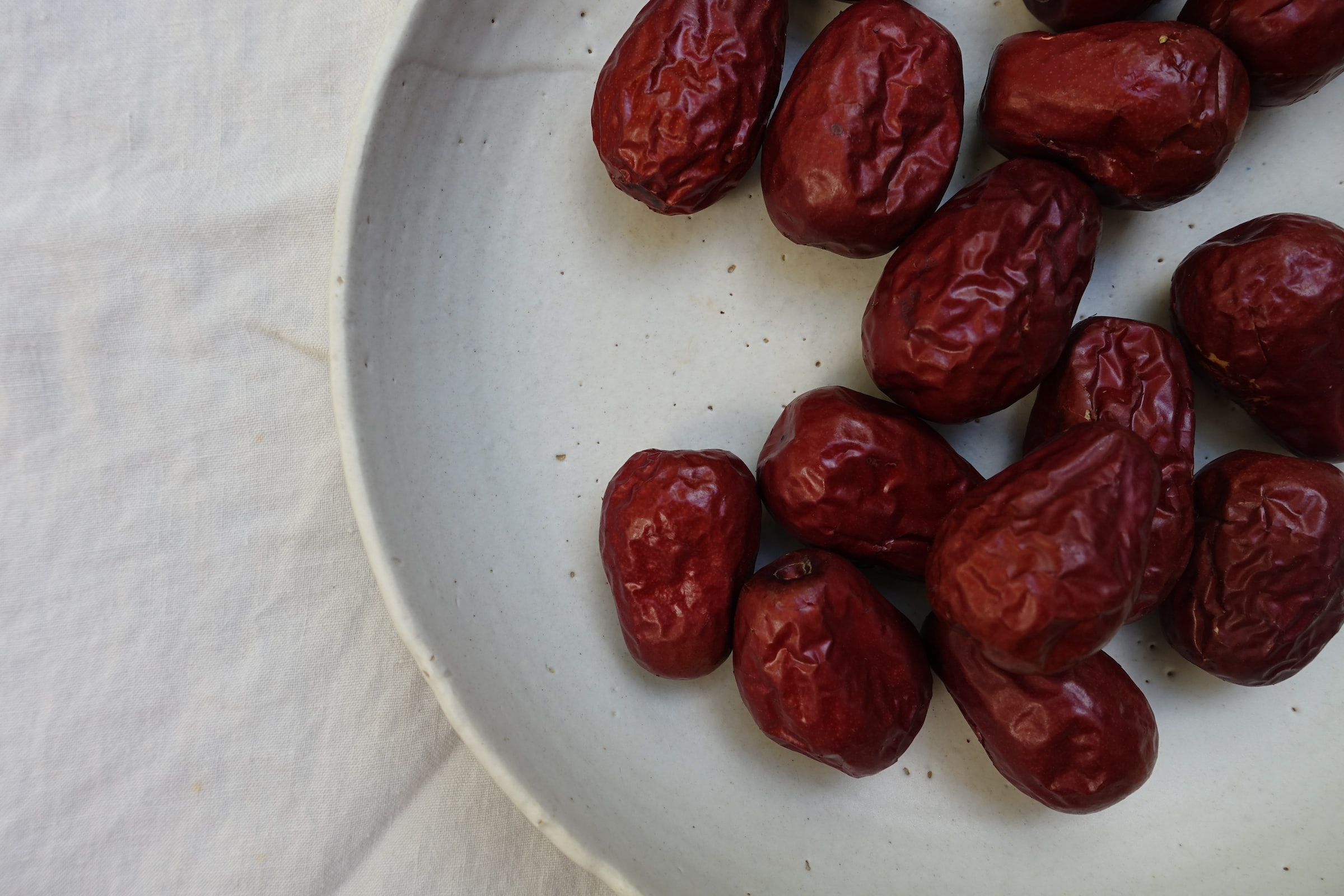 dried red berries on a white plate—how to grow jujube from seed